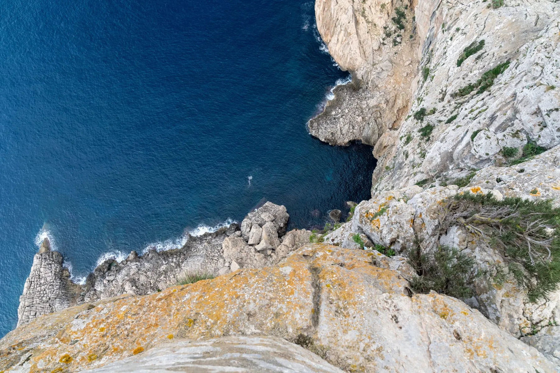 A dark cliff dropping into deep blue Atlantic water
